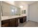 Bright bathroom with double sinks, dark wood cabinets, and a large mirror at 10348 E Tupelo Ave, Mesa, AZ 85212