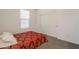 This bedroom features a window with blinds, a red patterned bedspread, and a closet with double sliding doors at 10348 E Tupelo Ave, Mesa, AZ 85212