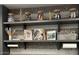 Shelving display with decorative jars, wooden figures, art books, and art supplies adding character to this wallspace at 10348 E Tupelo Ave, Mesa, AZ 85212