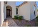 Inviting entrance with a dark wood door and manicured landscaping leading to the home at 10348 E Tupelo Ave, Mesa, AZ 85212