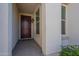 Cozy covered porch area with a dark wood front door and a small garden on the side at 10348 E Tupelo Ave, Mesa, AZ 85212