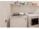 The laundry room features a side-by-side washer and dryer, and a shelf above with storage containers at 10348 E Tupelo Ave, Mesa, AZ 85212