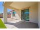 The covered patio provides a shaded area, featuring concrete and brick flooring, overlooking the backyard at 10348 E Tupelo Ave, Mesa, AZ 85212