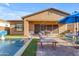 Spacious backyard with a pool, covered patio, and ample outdoor seating perfect for entertaining friends and Gathering at 10650 E Palladium Dr, Mesa, AZ 85212