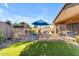 Charming backyard with an outdoor fireplace, comfortable seating, and lush green grass, perfect for relaxation at 10650 E Palladium Dr, Mesa, AZ 85212