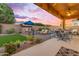 Inviting backyard with a fireplace, outdoor seating, and lush landscaping, creating a perfect spot for entertaining at 10650 E Palladium Dr, Mesa, AZ 85212
