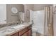 Well-lit bathroom features granite countertops, dark wood cabinetry, and a shower-tub combo with neutral tile at 10650 E Palladium Dr, Mesa, AZ 85212