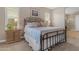 Bedroom with a metal bed frame, neutral bedding, wood nightstand, and bright natural lighting at 10650 E Palladium Dr, Mesa, AZ 85212