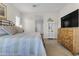 Bright bedroom with a wrought iron bed, neutral walls, and a TV atop a dresser with stylish decorations at 10650 E Palladium Dr, Mesa, AZ 85212