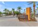 View of the community entrance sign surrounded by lush landscaping and a tree-lined walkway at 10650 E Palladium Dr, Mesa, AZ 85212