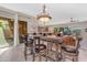 Open-concept dining area with a wooden table set for six, and views into the kitchen and living area at 10650 E Palladium Dr, Mesa, AZ 85212