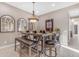 Dining area with wooden table, upholstered chairs, and decorative mirrors, adjacent to living area at 10650 E Palladium Dr, Mesa, AZ 85212