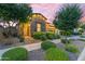 Charming stone accented home featuring lush landscaping, mature trees, and festive outdoor lighting at 10650 E Palladium Dr, Mesa, AZ 85212