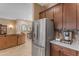 Stainless steel refrigerator in kitchen with brown cabinetry, quartz countertops, and tile backsplash at 10650 E Palladium Dr, Mesa, AZ 85212