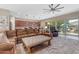 Living room showcasing a large sectional sofa, ceiling fan, and access to the kitchen and backyard at 10650 E Palladium Dr, Mesa, AZ 85212