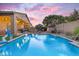 Twilight image of the luxurious pool complete with lights and multiple fountains, plus a fireplace for cozy evenings at 10650 E Palladium Dr, Mesa, AZ 85212