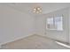 Bedroom with carpet flooring, neutral paint, window, and contemporary light fixture at 12117 N 127Th Dr, El Mirage, AZ 85335