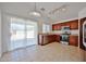 Well-lit kitchen with dark cabinetry, stainless steel appliances, and access to a patio at 12117 N 127Th Dr, El Mirage, AZ 85335