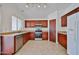 Well-lit kitchen featuring dark cabinetry, stainless steel appliances, and tile flooring at 12117 N 127Th Dr, El Mirage, AZ 85335