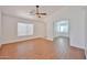 Bright living room featuring wood-look floors, white walls, and large windows for natural light at 12117 N 127Th Dr, El Mirage, AZ 85335