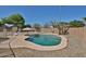 Backyard pool with lush landscaping, waterfall feature, lounge chairs, and a nice umbrella at 12117 N 127Th Dr, El Mirage, AZ 85335