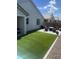 Cozy backyard featuring artificial turf, a patio dining set, and ambient string lights for outdoor enjoyment at 14338 W Bronco Trl, Surprise, AZ 85387