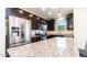 Open kitchen featuring stainless steel appliances, granite countertops, and dark wood cabinetry at 14338 W Bronco Trl, Surprise, AZ 85387