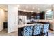 Stylish kitchen with stainless steel appliances, granite counters, dark wood cabinets and an island with bar stool seating at 14338 W Bronco Trl, Surprise, AZ 85387