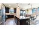 Bright open kitchen with stainless steel appliances, granite countertops, dark wood cabinets, and adjacent dining area at 14338 W Bronco Trl, Surprise, AZ 85387