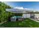 Outdoor seating area features a shaded patio with furniture, surrounded by lush greenery and an artificial turf lawn at 1522 W Willetta St, Phoenix, AZ 85007