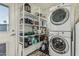 Organized laundry room with stacked washer and dryer and shelving for ample storage at 1522 W Willetta St, Phoenix, AZ 85007