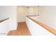 Upstairs hallway with wood floors, railing, and modern lighting at 16644 N 33Rd St # 101, Phoenix, AZ 85032
