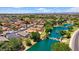 Aerial view showcasing houses with solar panels near a scenic lake and lush greenery at 17115 N Larkspur Ln, Surprise, AZ 85374