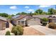 Single-story home featuring solar panels, two-car garage, and low-maintenance desert landscaping at 17115 N Larkspur Ln, Surprise, AZ 85374