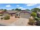 Front exterior of home featuring solar panels on roof and low maintenance desert landscaping at 17115 N Larkspur Ln, Surprise, AZ 85374