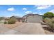 Single-story home with a two-car garage and low maintenance desert landscaping at 17115 N Larkspur Ln, Surprise, AZ 85374