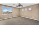 Bedroom featuring neutral carpet, ceiling fan, and a bright window with neighborhood views at 1755 E Tonto Dr, Chandler, AZ 85249
