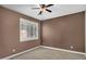 Cozy bedroom featuring a ceiling fan, neutral carpet, and plantation shutters for privacy at 1755 E Tonto Dr, Chandler, AZ 85249