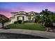 Elegant two-story home with a lush green lawn, palm trees, and a charming facade at 1755 E Tonto Dr, Chandler, AZ 85249