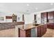 Kitchen island has a granite countertop and stone accents that overlook the living room fireplace at 1755 E Tonto Dr, Chandler, AZ 85249