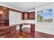 Home office featuring custom built-in shelving and cabinetry with hardwood floors at 1755 E Tonto Dr, Chandler, AZ 85249