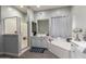Bathroom featuring shower, soaking tub and vanity with gray cabinets, providing a calming space to relax at 18474 W College Dr, Goodyear, AZ 85395