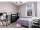 Bedroom featuring a cozy single bed, organized storage, and a window providing natural light at 18474 W College Dr, Goodyear, AZ 85395