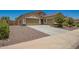 View of the three-car garage with desert landscaping for low maintenance and curb appeal at 18474 W College Dr, Goodyear, AZ 85395