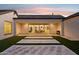 Beautiful backyard patio featuring large glass doors and a tile and grass design under a lovely twilight sky at 19910 E Vallejo St, Queen Creek, AZ 85142