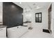 Modern bathroom featuring a soaking tub, black tile accent wall, and white cabinetry at 19910 E Vallejo St, Queen Creek, AZ 85142
