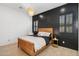 Well-decorated bedroom with a wood accent wall, wooden furniture, and hardwood floors at 19910 E Vallejo St, Queen Creek, AZ 85142