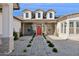 Striking single-story home with a welcoming red door, beautiful landscaping, and a brick pathway at 19910 E Vallejo St, Queen Creek, AZ 85142