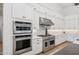 Gourmet kitchen featuring stainless steel appliances, custom white cabinets, and modern fixtures at 19910 E Vallejo St, Queen Creek, AZ 85142