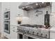 Close-up of the gourmet kitchen featuring stainless steel appliances, a range hood, and herringbone backsplash at 19910 E Vallejo St, Queen Creek, AZ 85142